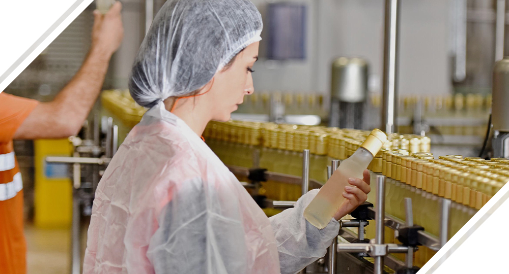 Female employee checking glass bottle